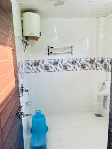 a bathroom with a toilet with a blue stool in it at Vrundavan home stay and Village resort in Kevadia