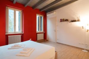 a red room with a bed with two towels on it at Appartamento Scaligero Mameli Borgo Trento in Verona