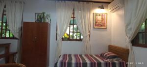 a room with a table and two windows at Dulangan Puerto Galera Transient Place in Puerto Galera