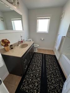 La salle de bains est pourvue d'un lavabo, de toilettes et d'un miroir. dans l'établissement Waterfront cozy cottage., à Port Perry