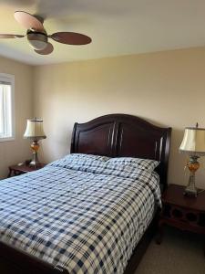 - une chambre avec un lit doté d'une couverture en damier bleu et blanc dans l'établissement Waterfront cozy cottage., à Port Perry