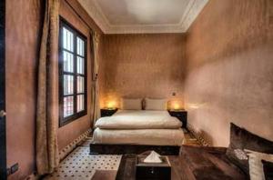 een slaapkamer met 2 bedden en een groot raam bij RIAD N° 16 in Marrakesh