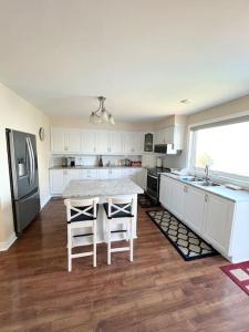 a kitchen with white cabinets and a table and chairs at Waterfront cozy cottage. in Port Perry