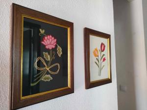 duas fotos de flores estão penduradas numa parede em Casa do Duque em Arneiro