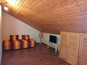 a bedroom with a bed with orange sheets and a television at Casa do Duque in Arneiro