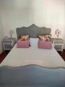 um quarto com uma cama grande e duas mesas em Casa do Duque em Arneiro