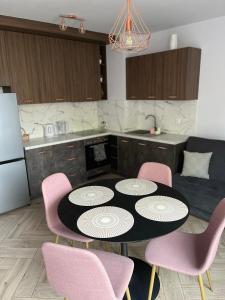 uma cozinha com uma mesa e quatro cadeiras cor-de-rosa em Złotów-ka em Złotów