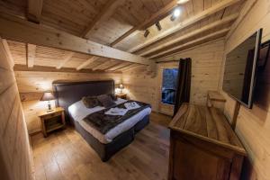 een slaapkamer met een bed in een blokhut bij Chalet Krystal in Les Carroz d'Araches