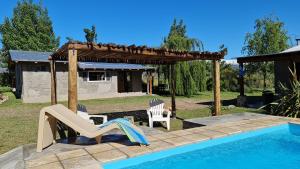 einen Hinterhof mit einem Pool und einem Pavillon in der Unterkunft Espacio Nux in Los Árboles