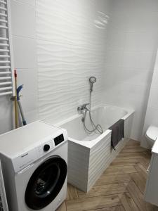 uma casa de banho branca com uma máquina de lavar roupa na banheira em Złotów-ka em Złotów