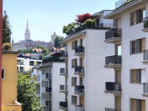 a tall white building with balconies and a city at Castle Corner Apartment in Budapest