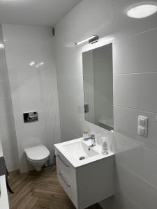 a white bathroom with a sink and a toilet at Złotów-ka in Złotów