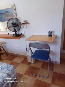 a desk with a chair and a fan in a room at Habitaciones Gioly in Puerto del Rosario