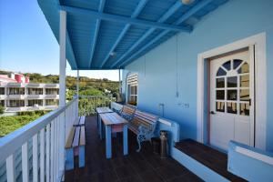 小琉球的住宿－薇多莉亞鄉村花園民宿，阳台设有长椅和蓝色墙壁上的桌子
