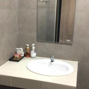清萊的住宿－Mae Kok River Cliff Residence，浴室水槽设有镜子和白色水槽