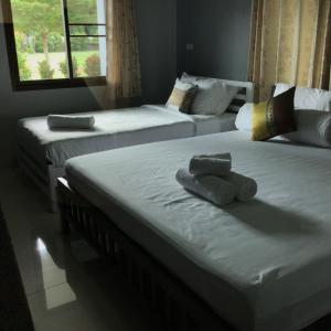 three beds in a room with towels on them at Mae Kok River Cliff Residence in Chiang Rai