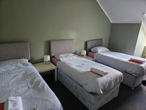 a room with two beds and two tables in it at Cunninghame 3 in Beith