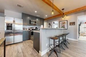 cocina con electrodomésticos de acero inoxidable y suelo de madera en Meadow Creek Cottage en Wimberley