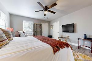 1 dormitorio con 1 cama y ventilador de techo en Meadow Creek Cottage en Wimberley