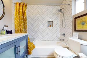 a bathroom with a white toilet and a yellow shower curtain at Meadow Creek Cottage in Wimberley +18 photos