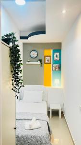 een slaapkamer met een wit bed en een plant bij Glamorous Partition Room in Barsha 1 Near Metro in Dubai