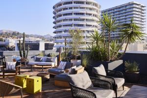 a patio with chairs and tables and a building at The Aster in Los Angeles