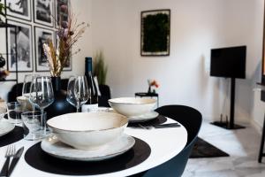 een tafel met twee kommen en wijnglazen erop bij [Angolo45]Vista Inedita su Udine in Passons
