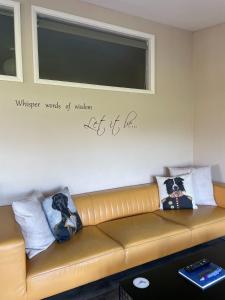 a brown leather couch in a room with a window at Let It Be in Liverpool