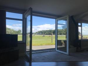 uma porta de vidro aberta com vista para um campo em Let It Be em Liverpool