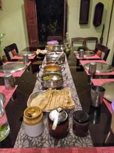 ビサーリーにあるSundara Mahal Homestay Wayanadの長いテーブルに盛り付けられたお皿