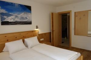 a bedroom with a white bed and a mirror at Landhaus Dangl in Fliess
