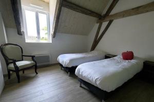 a room with two beds and a chair and a window at Le Gîte - Le Pressoir in Les Molières