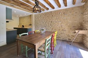eine Küche und ein Esszimmer mit einem Holztisch und Stühlen in der Unterkunft Le Gîte - Le Pressoir in Les Molières