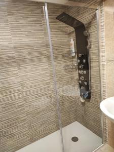 a shower with a glass door next to a sink at Adosado en Alcossebre El Faro in Alcossebre