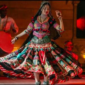 a woman in a colorful dress dancing on a stage at Magic Heritage Camp & Resort in Jaisalmer