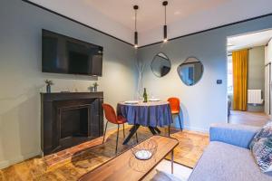 uma sala de estar com uma mesa e uma lareira em Art Déco Lesage & Spa em Reims