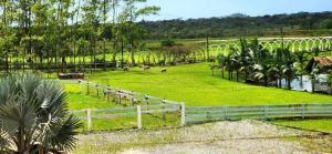 a white fence in a field with animals in it at Fazenda Lago do Cisne in Itapoa
