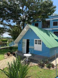 a blue house with a green roof at Meu Chalé in Miguel Pereira