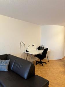 a living room with a couch and a desk with a computer at Hübsches Apartment im Herzen Verdens in Verden