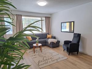 a living room with a blue couch and a chair at Seaside apartment in Rauma