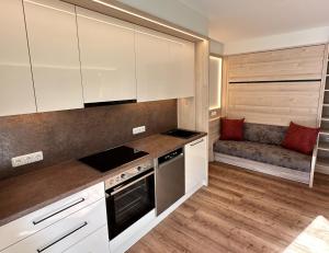 芬肯貝格的住宿－Appartementhaus Zillertal by PiaundDirk，厨房配有白色橱柜和沙发。