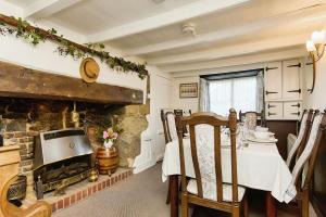 a living room with a fireplace and a table and chairs at Ye Olde Cottage in Niton