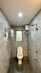 a bathroom with a toilet and a shower at Iris Villa - Nagaon Beach in Nagaon