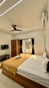 a bedroom with a large bed with a ceiling at Iris Villa - Nagaon Beach in Nagaon