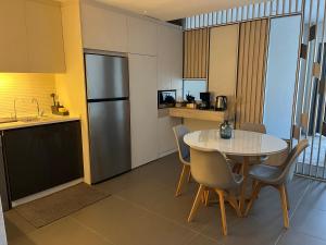 a small kitchen with a table and a refrigerator at DAMAC Luxury new 1 bedroom apartment in Amman