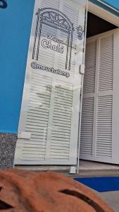 a white garage door with a sign on it at Meu Chalé in Miguel Pereira