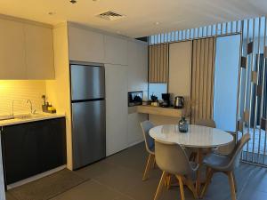 a small kitchen with a table and a refrigerator at DAMAC Luxury new 1 bedroom apartment in Amman