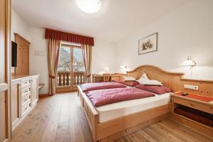 ein Schlafzimmer mit einem großen Bett und einem Fenster in der Unterkunft Tommelehof in Algund