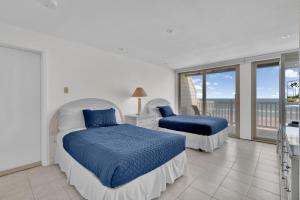 a bedroom with two beds and a balcony at First level with a secluded patio in South Padre Island