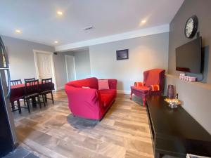 a living room with two red chairs and a tv at lovely home in Calgary